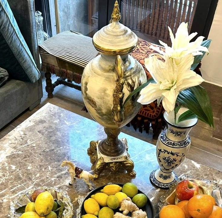 Urna de porcelana pintada con bronces sobre una mesa de mármol