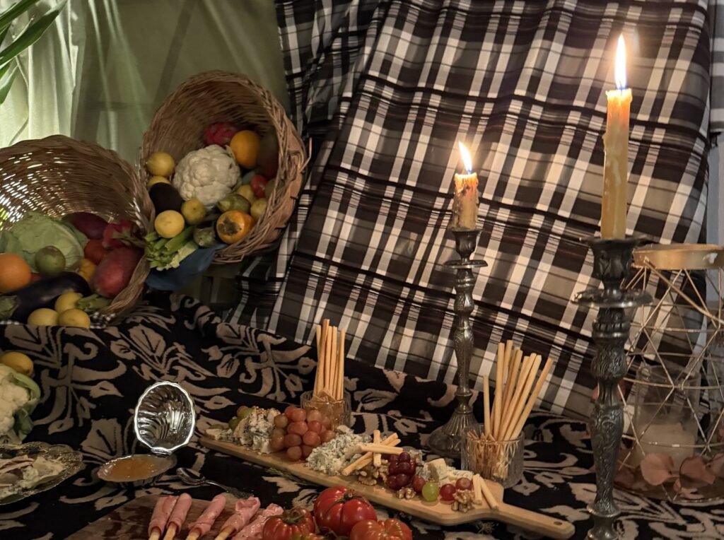 Mesa con velas, cestas de fruta y tablas en Usera