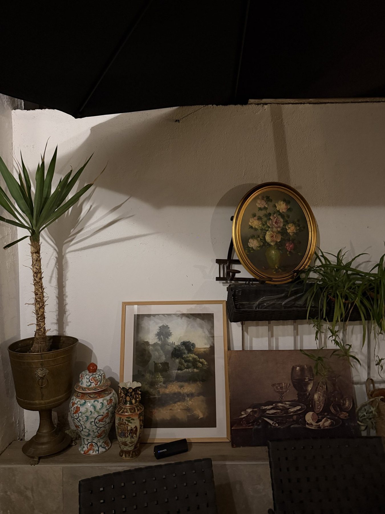 Pared con cuadros, una palmera y jarrones orientales